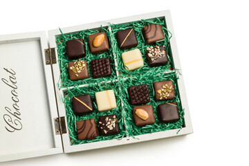 Assorted chocolates in a wooden gift box on white background.
