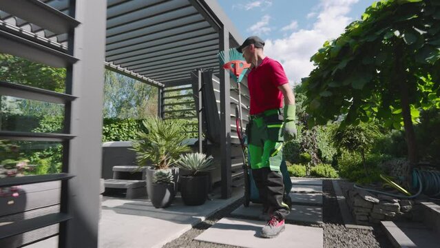 Gardener Using Leaf Blower in Garden on Sunny Day