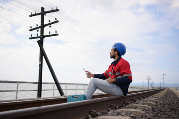 Engineer railway under checking construction process train testing and checking railway work on railroad station with radio communication .Engineer wearing safety uniform and safety helmet in work.