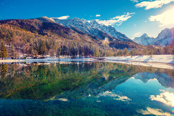 Obraz premium Mountain valley with the river in winter. The tops of the mountains are covered with snow. View of the Alps in Kranjska Gora at sunrise. Triglav national park. Slovenia, Europe
