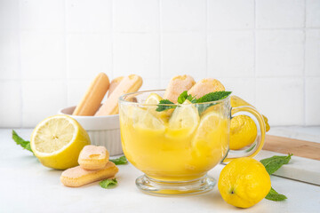 Fototapeta premium Lemon Pudding Dessert on Glass cup. Layered parfait dessert with cookies and lemon slices, copy space