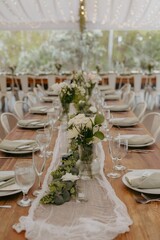 Elegant table setting with floral centerpiece and soft lighting at an outdoor wedding reception