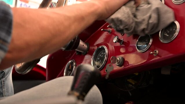 Automotive Enthusiast Cleaning a Classic Car Dashboard With a Cloth