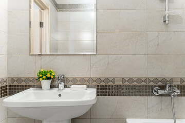 modern bathroom design with light-colored tiles, white furniture and a white toilet bowl. Bathroom mirror