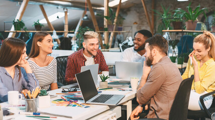 Creative start-up team discussing ideas in modern office. Designers working on new project
