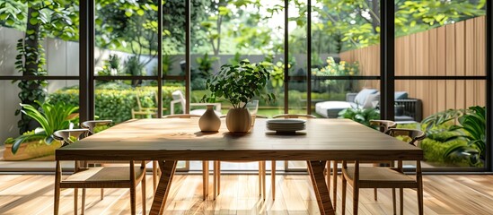 Dining table in dining area in living room of apartment with windows and glass doors leading to garden. with copy space image. Place for adding text or design