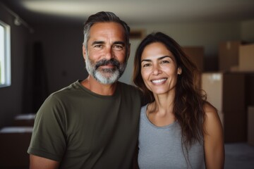 Portrait of a smiling middle aged Hispanic couple in new home