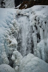 magnificent Dynjandi waterfall in Iceland is covered in a stunning blanket of ice and snow, creating a truly breathtaking sight