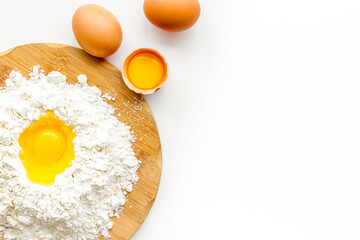 Making dough concept. Pile of flour and eggs on white background top view copy space