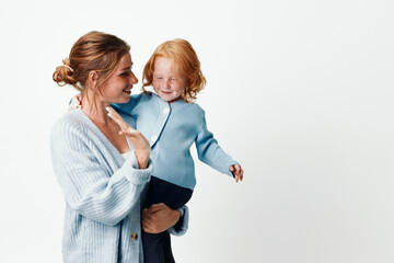 Mother and child smiling in front of white background, happiness and family concept, love and careful parenting portrait