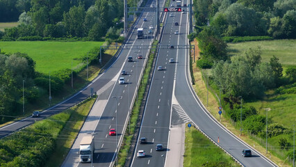 AERIAL: Smooth daily traffic passing the intersection on a modern city highway
