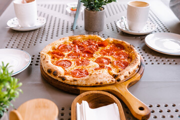 Pepperoni pizza on a table in a pizzeria.