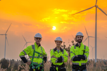 Team Engineers men and woman checking and inspecting on construction with sunset sky. people operation. Wind turbine for electrical of clean energy and environment. Industrial of sustainable.