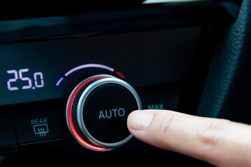 Process of press auto climate control in the car. Woman regulating temperature on car air conditioner.