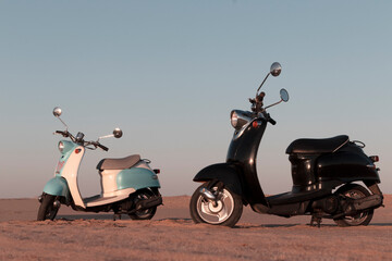 Two Retro scooters at sunset in the golden sand of the Namib Desert