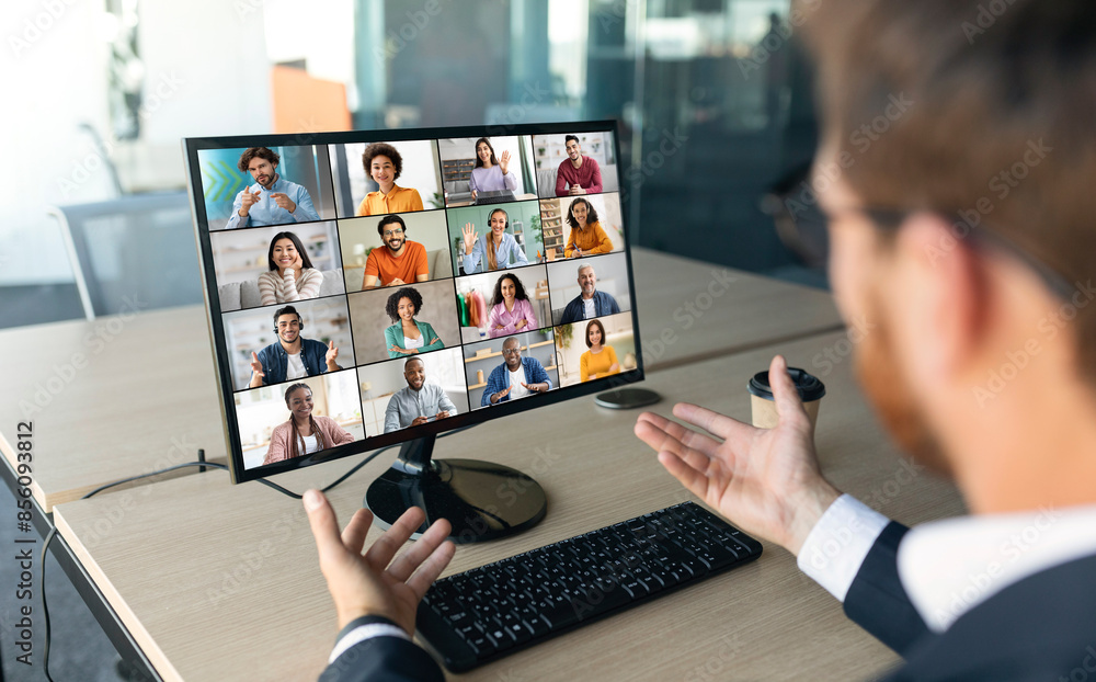 Poster a businessman sits at a desk in his office, with a computer screen displaying a video conference cal