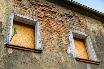 Boarded Up Windows On An Old Brick Building In Daylight