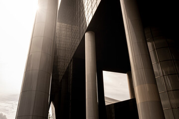 Abstract composition focusing on the structural pillars of a skyscraper in Rotterdam, presenting a dramatic play of light, shadow, and form