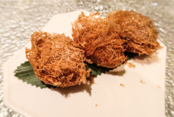 close up of three pieces of Chinese Cantonese Hong Kong style dim sum dim fried crispy taro yam dumpling puff on a white plate