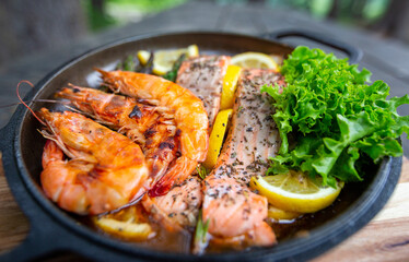 Healthy baked salmon steaks with greens and asparagus in a black cast iron skillet. A delicious low-carb breakfast.