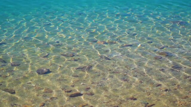 Slow motion shot of water ripples on the Chandra Taal Lake near Kunzum Pass in Spiti Valley, Himachal Pradesh, India. Water ripples on the blue water of Chandra Tal lake due to the strong winds.	