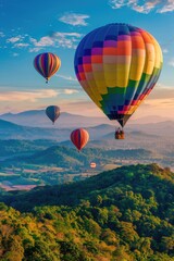 Naklejka premium Hot air balloons soaring above a lush green hillside with rolling hills and blue sky