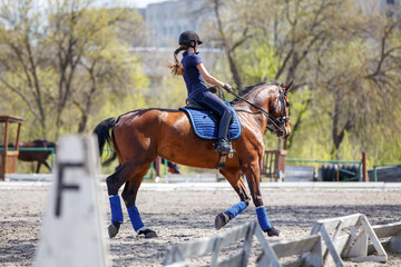 Young rider girl riding horse during dressage training