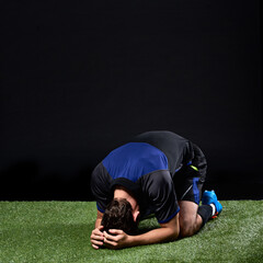 Field, soccer player and man in grass, fail and frustrated in game, stress and upset on ground in...