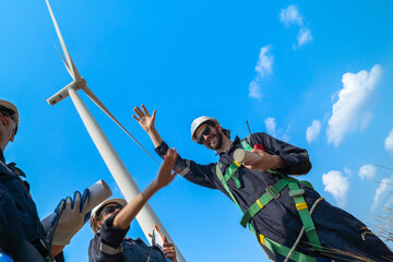 The engineering team joins hands with confidence after completing the inspection of the wind...