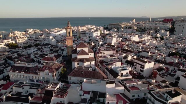 Aerial View of a Beautiful Coastal Cityscape with a Historic Church Tower and scenic ocean backdrop