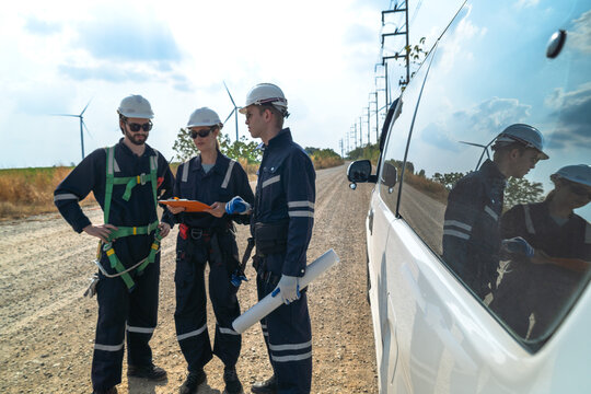 A team of engineers is inspecting the construction of wind turbines and surrounding structures in remote areas to produce clean electricity and help with sustainability and reduce global pollution.
