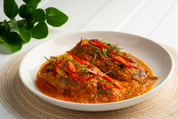Fish with Red Curry Sauce,Thai food,Climbing gourami fish in Dried spicy curry paste mix with coconut milk in white plate