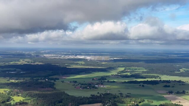 Descent and approach and landing from cockpit of airplane, plane aircraft in Stockholm Arlanda airport in summer with green grass fields and forest