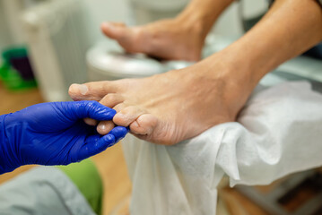 Fototapeta premium concept of male pedicure, cosmetologist makes classic pedicure for an elderly male client.