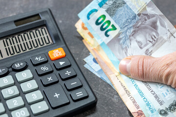 Brazilian Reais banknotes, Calculator and money file, financial settlements, household budget,...