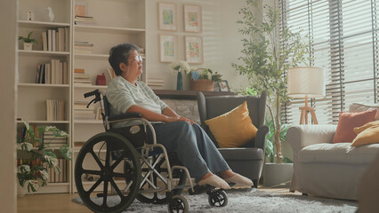 old senior retired woman in wheelchair Thoughtful asian senior woman sitting on wheelchair at home. Elderly female is looking through window elder woman in wheelchair alone at home