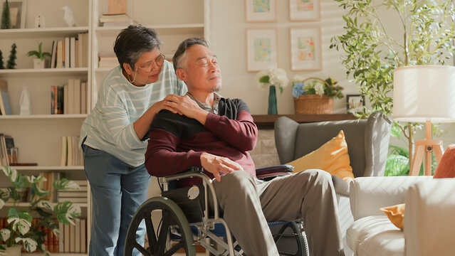 Asain elderly couple talked with understanding and embraced each other Asian senior marry couple on wheel chair with his wife at home feeling encurage and stress worry eye expression