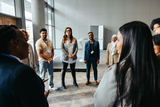 Diverse business professionals discussing during team building event in modern office space