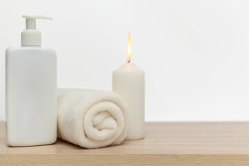 White candle, white towel, white cleaner. Place for text.