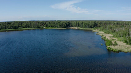 A lake in the middle of the Estonian Woods. Aerial view of the landscape and some Cabins, around the country are many lakes like this with clear and clean cold watter 