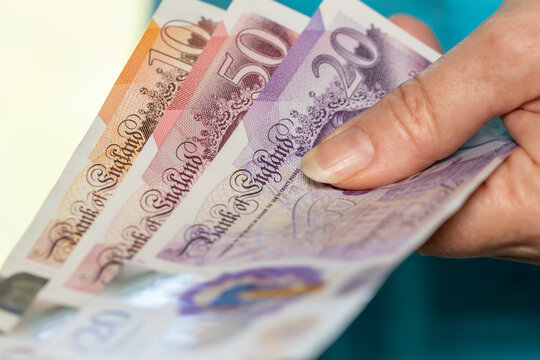 Great Britain money, British woman holds English pounds in her hand, economic concept, UK finance