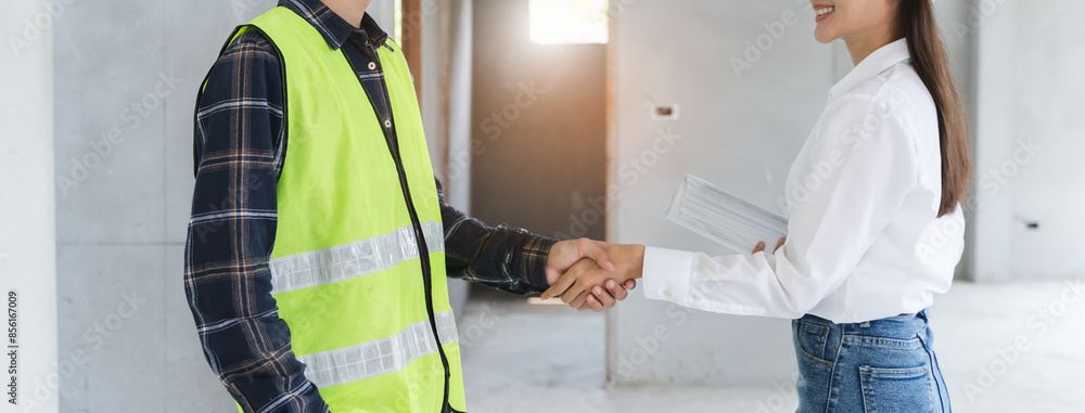 Wall mural construction worker and contractor. Client shaking hands with team builder in renovation site.