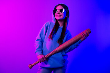 Obraz premium Photo of cool dreamy little lady dressed hoodie holding batter looking empty space isolated neon pink color background