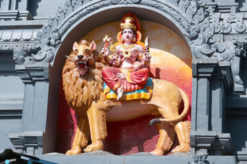 Goddess Durga riding a lion. Bas-relief on a Hindu temple in India.