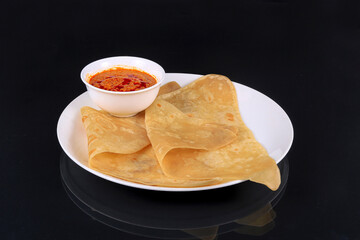 Chapati, traditional Indian flatbreads with fresh parsley on a gray background.