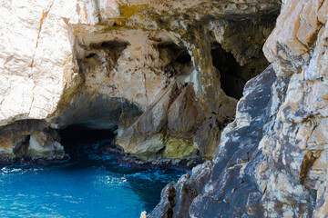 Detallada vista de los acantilados y la entrada a la Cueva de Neptuno en Cabo Caccia, Cerdeña, Italia. Las formaciones de roca caliza, con tonos blancos y marrones. 