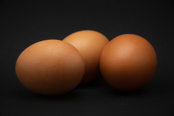side view of chicken egg on black background