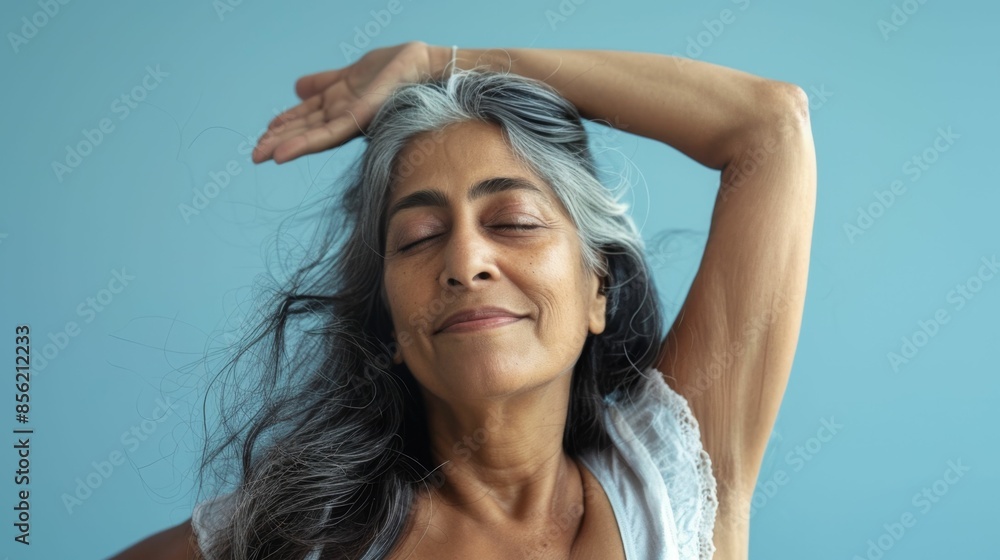 Sticker Woman with gray hair closed eyes and a serene expression raising her hand to her forehead against a light blue background.