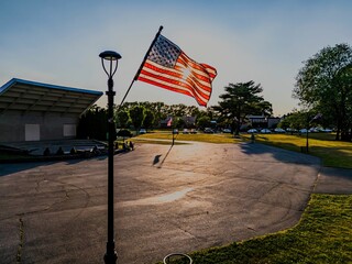 Low angle view of the American flag flying in the wind on a sunny afternoon at a local park