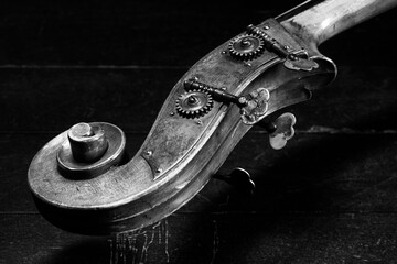 Close up. Ancient double bass neck, double bass scroll and tuning pegs, music concept. Shallow depth of field. Black and white image	